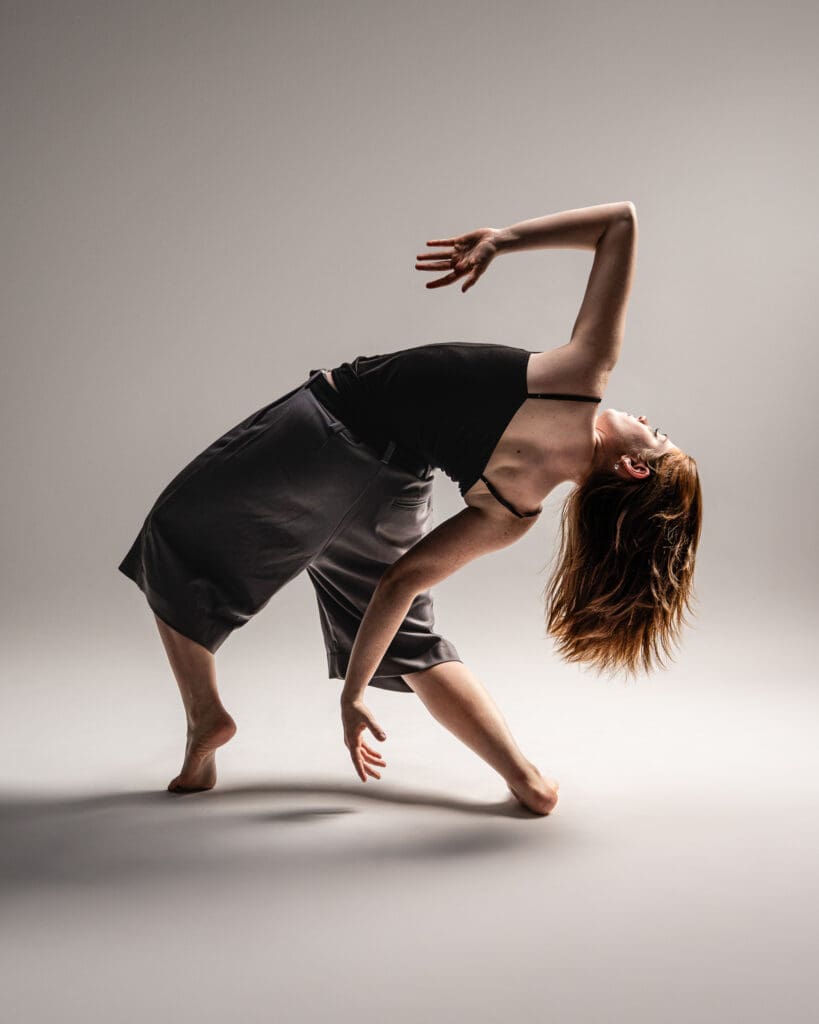 Contemporary dancer leaning back on paper backdrop.