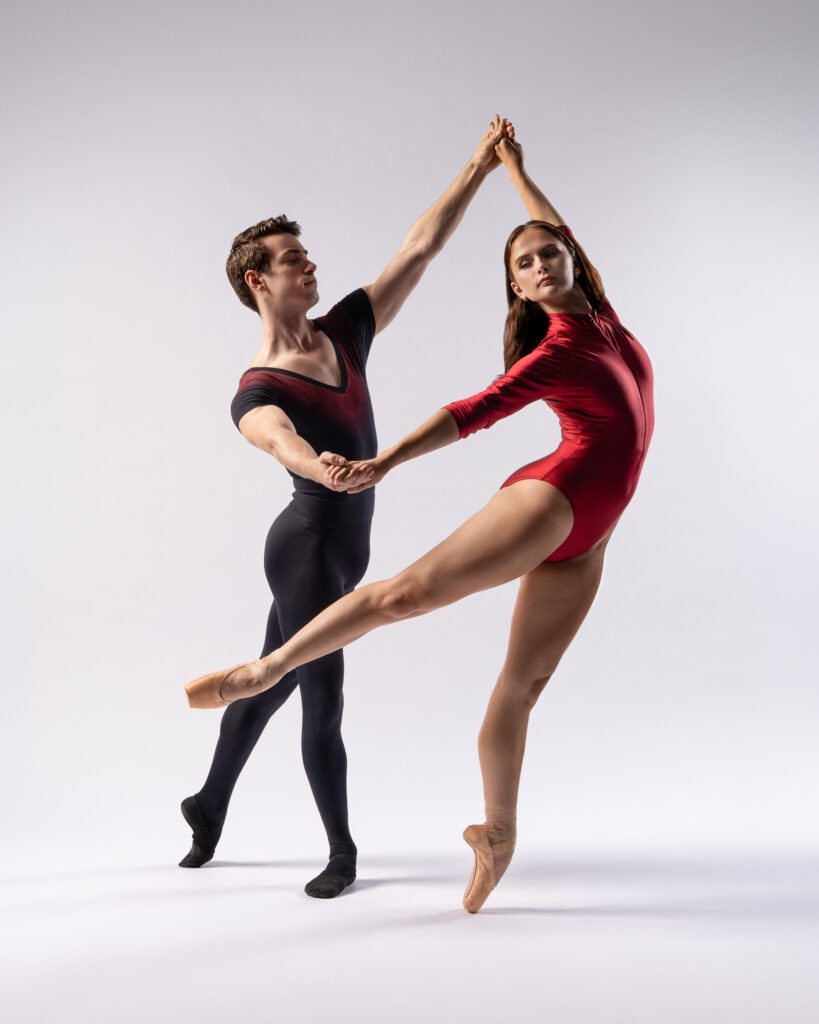 Male and female ballet dancers execute a partnered lift in a San Antonio dance session, with the female dancer en pointe and leg extended high